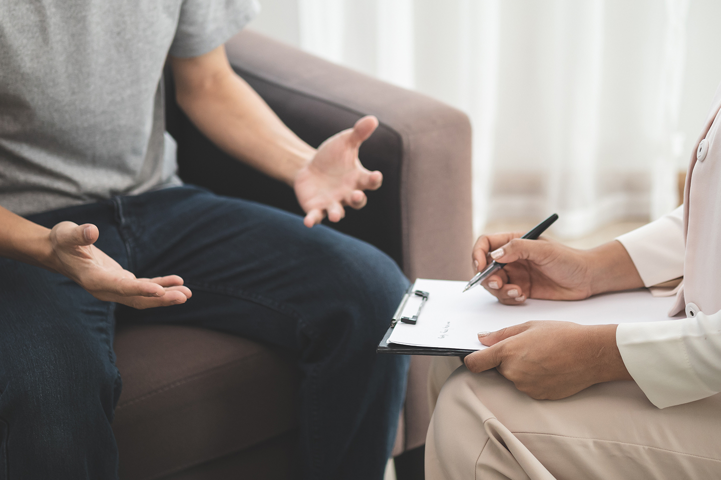 Urologist showing a male reproductive system model to a seated patient